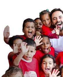 Un groupe d'enfants souriants faisant signe de la main, portant des t-shirts rouges Colgate, aux côtés d'un homme souriant en chemise blanche.